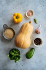 Vista superior dos ingredientes para preparar prato vegetariano com abóbora amarela fresca no fundo de pedra — Fotografia de Stock