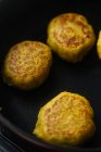 De arriba las croquetas sabrosas hortalizas con dorado castaño oscuro que preparan en la cacerola a la estufa en la cocina - foto de stock