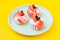 Von oben schmackhafte Desserts mit frischen Erdbeeren und Blumen auf Teller auf gelbem Hintergrund — Stockfoto