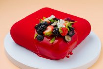 Pastel rojo con bayas frescas - foto de stock