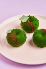 Donuts mit grünem Sahnehäubchen auf Teller — Stockfoto