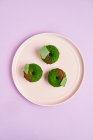 Пончики с зеленой глазурью на тарелке — стоковое фото