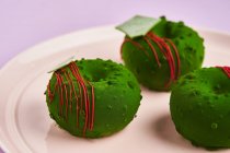 Donuts mit grünem Sahnehäubchen auf Teller — Stockfoto