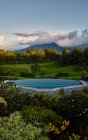 Schwimmbad mit sauberem Wasser in der Nähe exotischer Pflanzen im grünen Tal in der Nähe des Berggipfels am bewölkten Abend in Costa Rica — Stockfoto