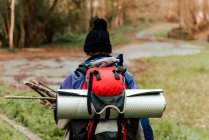 Unrecognizable backpacker trekking in autumn forest — Stock Photo