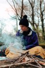 Junge Backpackerin macht sich Notizen am Lagerfeuer — Stockfoto