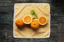 Metades de laranjas frescas em uma mesa rústica escura de madeira em um fundo escuro — Fotografia de Stock