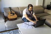 Орієнтований чоловік працює з ноутбуком у вітальні — стокове фото