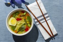 From above top view oriental ramen healthy noodles soup with shiitake, spinach, carrots, eggs and chillies on restaurant table — Stock Photo