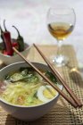 From above oriental ramen healthy noodles soup with shiitake, spinach, carrots, eggs and chillies on restaurant table — Stock Photo