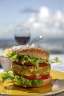 Домашний здоровый веганский зеленый чечевичный бургер с помидорами, салатом и картошкой фри — стоковое фото