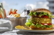 Домашній здоровий веганський зелений сочевичний бургер з помідорами, салатом та картоплею фрі — стокове фото