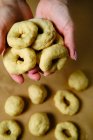 De cima anônimo mulher fazendo anéis de massa macia enquanto prepara donuts sobre mesa na cozinha — Fotografia de Stock