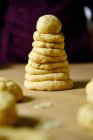 Ciambelle crude e palla fatta di pasta fresca e impilati insieme sul tavolo in cucina — Foto stock