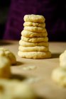Donuts crus e bola feita de massa fresca e empilhados juntos na mesa na cozinha — Fotografia de Stock