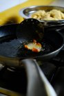 Зверху купка смачних пончиків, які смажать у гарячій бульбашковій олії на плиті на кухні — стокове фото