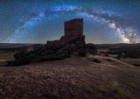 Remains of ancient castle under Milky Way at starry night with lantern light — Stock Photo