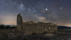 Restos del antiguo castillo bajo la Vía Láctea en la noche estrellada - foto de stock