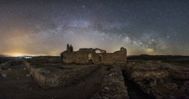 Restos del antiguo castillo bajo la Vía Láctea en la noche estrellada - foto de stock