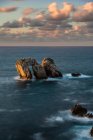 Do cenário acima pitoresco de rochas ásperas entre o mar azul calmo sob o céu colorido da noite com raios do sol que quebram através das nuvens durante o crepúsculo Costa Brava, Spain — Fotografia de Stock