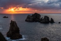Do cenário acima pitoresco de rochas ásperas entre o mar azul calmo sob o céu colorido da noite com raios do sol que quebram através das nuvens durante o crepúsculo Costa Brava, Spain — Fotografia de Stock