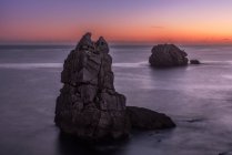 Von oben malerische Kulisse rauer Felsen inmitten ruhigen blauen Meeres unter buntem Abendhimmel mit Sonnenstrahlen, die in der Dämmerung die Wolken durchbrechen Costa Brava, Spanien — Stockfoto