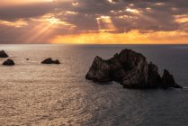 Von oben malerische Kulisse rauer Felsen inmitten ruhigen blauen Meeres unter buntem Abendhimmel mit Sonnenstrahlen, die in der Dämmerung die Wolken durchbrechen Costa Brava, Spanien — Stockfoto