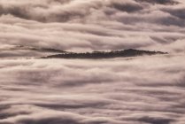 D'en haut des sommets noirs des montagnes puissantes parmi les nuages épais blancs doux — Photo de stock