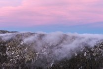 De cima de picos poderosos ásperos de falésias com beira-mar e céu noturno colorido no fundo — Fotografia de Stock