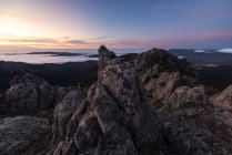 Von oben raue mächtige Gipfel der Klippen mit Meeresküste und buntem Abendhimmel im Hintergrund — Stockfoto