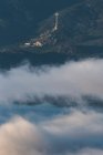 De cima da cidade velha na inclinação da colina entre floresta verde coberta com nevoeiro grosso abaixo do céu matutino colorido — Fotografia de Stock