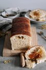 Dall'alto pezzo di pane brioche saporito su tavolo con pane su asse di legno in cucina — Foto stock