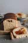 De acima mencionado pedaço de saboroso pão Brioche na mesa com pão em tábua de madeira na cozinha — Fotografia de Stock