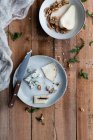 Сверху тарелки с вкусной грушей и салатом из грецких орехов с сыром и рукколой размещены на пилораме рядом с кулинарными ингредиентами — стоковое фото