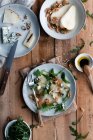 Vista dall'alto di gustosa insalata di pere con rucola posta su legname vicino a formaggio e noci in cucina — Foto stock