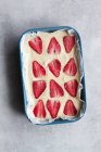 Vista dall'alto di appetitoso dolce dolce fatto in casa con panna bianca e fragola fresca affettata su sfondo di marmo — Foto stock