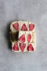 Vista dall'alto del taglio in pezzi delizioso dessert gelo fatto in casa con crema bianca e fragola affettata su sfondo di marmo — Foto stock