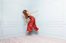Анонімний стильний танцюрист стрибає в кутку студії — стокове фото