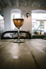 Verre de vin placé sur une table en planches de bois contre la lumière du jour depuis les fenêtres dans un restaurant rustique — Photo de stock