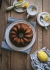 Draufsicht von oben leckerer frischer veganer Kuchen mit Zitrone und Kokosnuss auf Holztisch mit Zutaten — Stockfoto