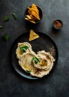 Top view of stylish black plate with delicious fresh eggplant and cauliflower dip stylish decorated with colorful spices and leaves of mint — Stock Photo
