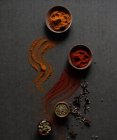 Top view composition with different kinds of natural aromatic spices placed on dark gray background with powder spice spilled on the surface — Stock Photo