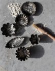 Vista dall'alto di vari stampi da forno in metallo e piccolo pennello da cucina sul tavolo di marmo cosparso di farina bianca — Foto stock