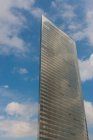 Grattacielo moderno contro il cielo nuvoloso blu — Foto stock