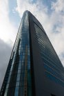 Grattacielo moderno contro il cielo nuvoloso blu — Foto stock