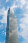 Von unten des zeitgenössischen Stadtturms vor blauem wolkenverhangenem Himmel, der sich an sonnigen Tagen in Japan in einer Glaswand spiegelt — Stockfoto