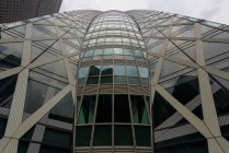 Moderna torre di vetro sotto cielo nuvoloso — Foto stock