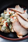 Slices of yummy ham arranged on vegetable salad with cream sauce on plate in cafeteria — Stock Photo