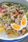 Großaufnahme leckerer Thunfischsalat mit Kartoffeln und Tomaten, gemischt mit Ei und Salat, serviert im Restaurant — Stockfoto