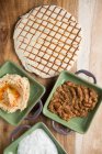 Draufsicht auf Teller mit verschiedenen Soßen auf Holztisch in der Nähe in Scheiben geschnitten gebratene Tortilla im Café platziert — Stockfoto